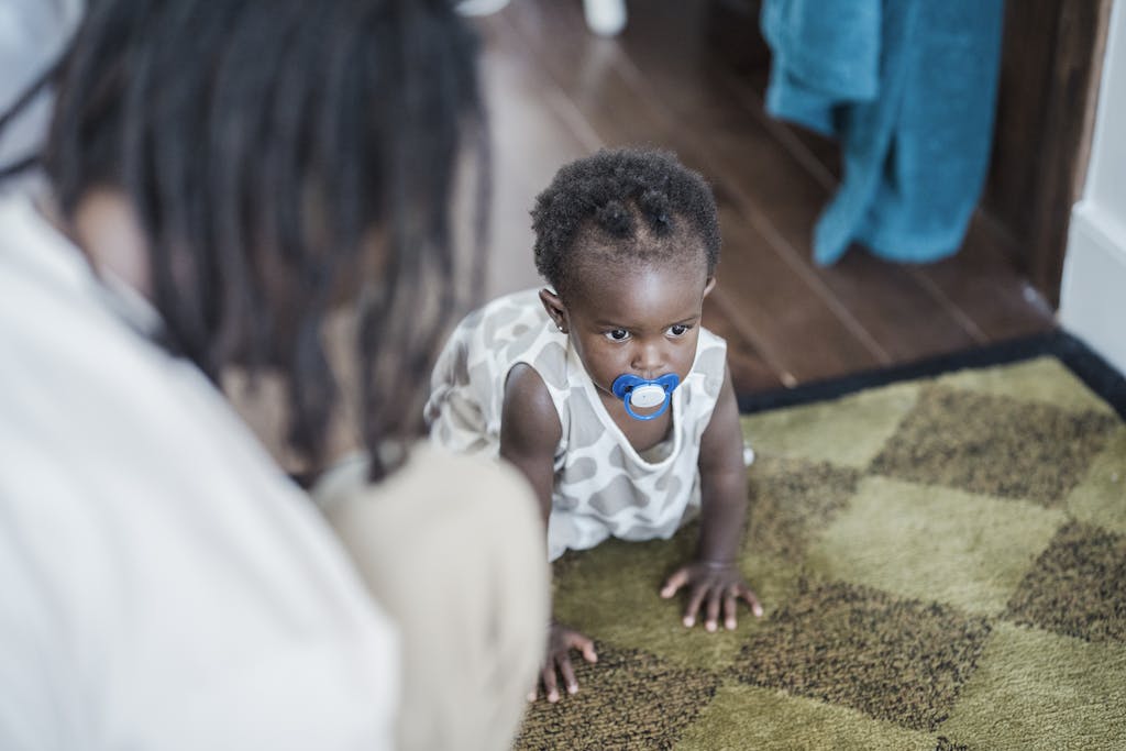 A Baby Crawling on a Wooden Floor