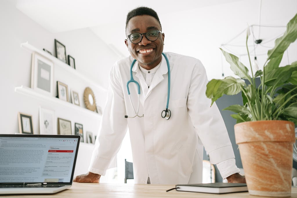 A Doctor Smiling while Leaning on the Table