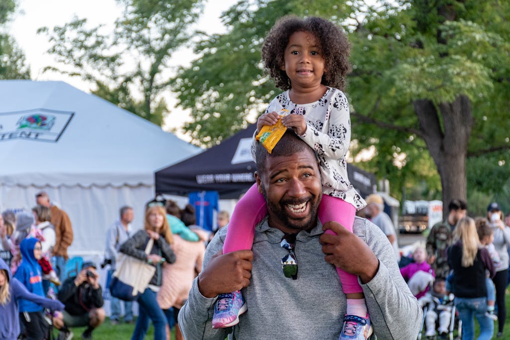 Girl Sitting on Smiling Man's Shoulder