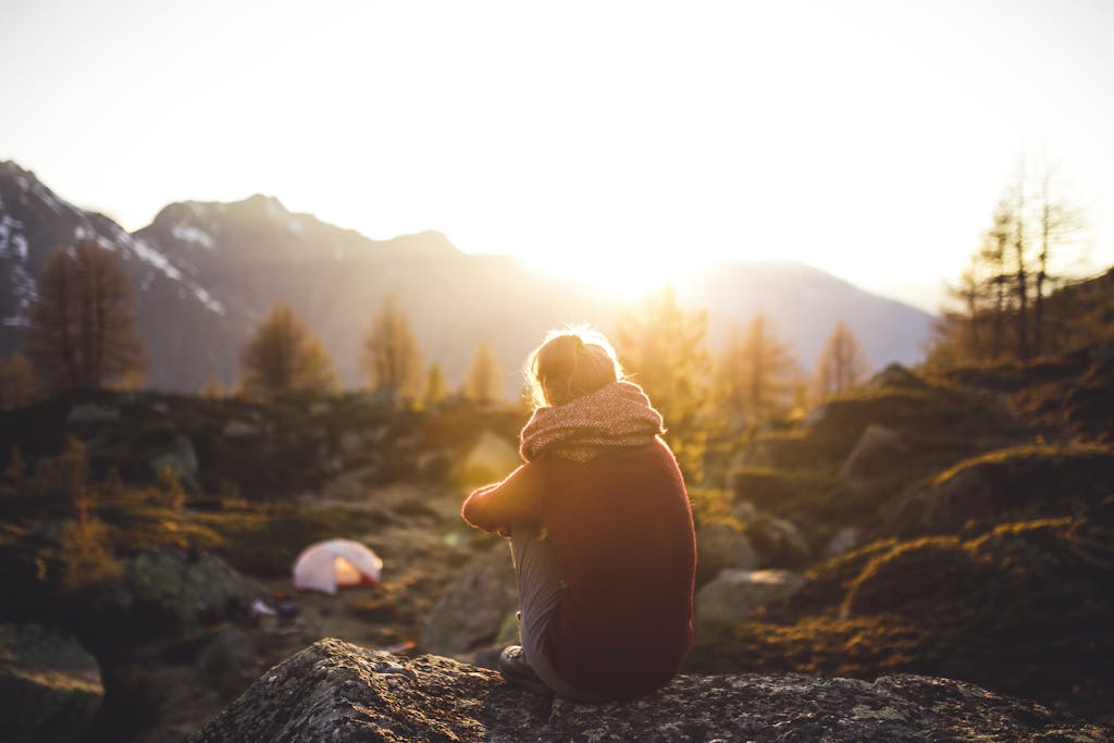 Person Sitting on Rock at Golden Hour