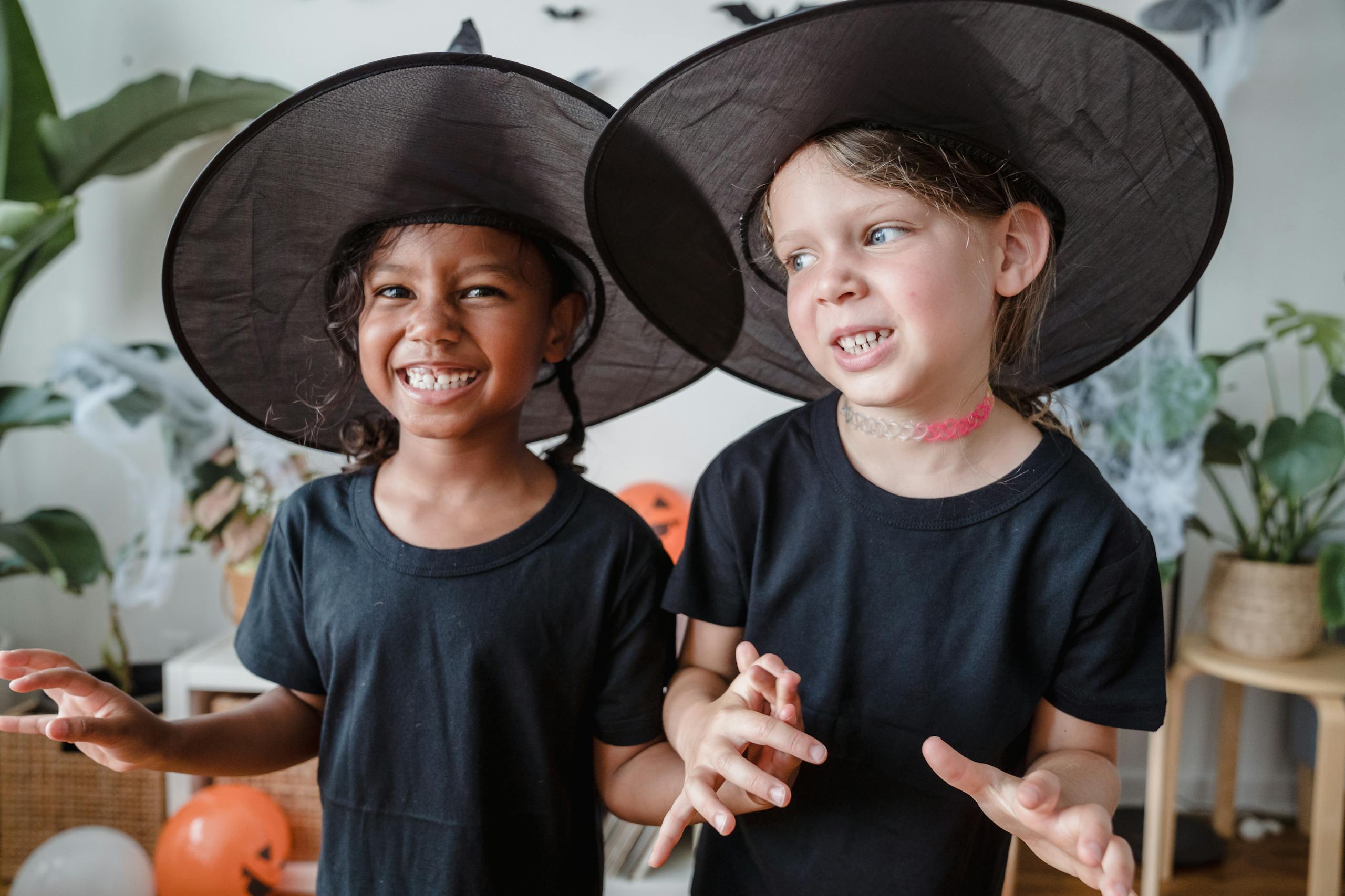 Two kids in witch hats smiling